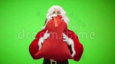 圣诞老人的肖像在绿色背景上赠<strong>送</strong>带<strong>有礼</strong>物的袋子。 慢动作。